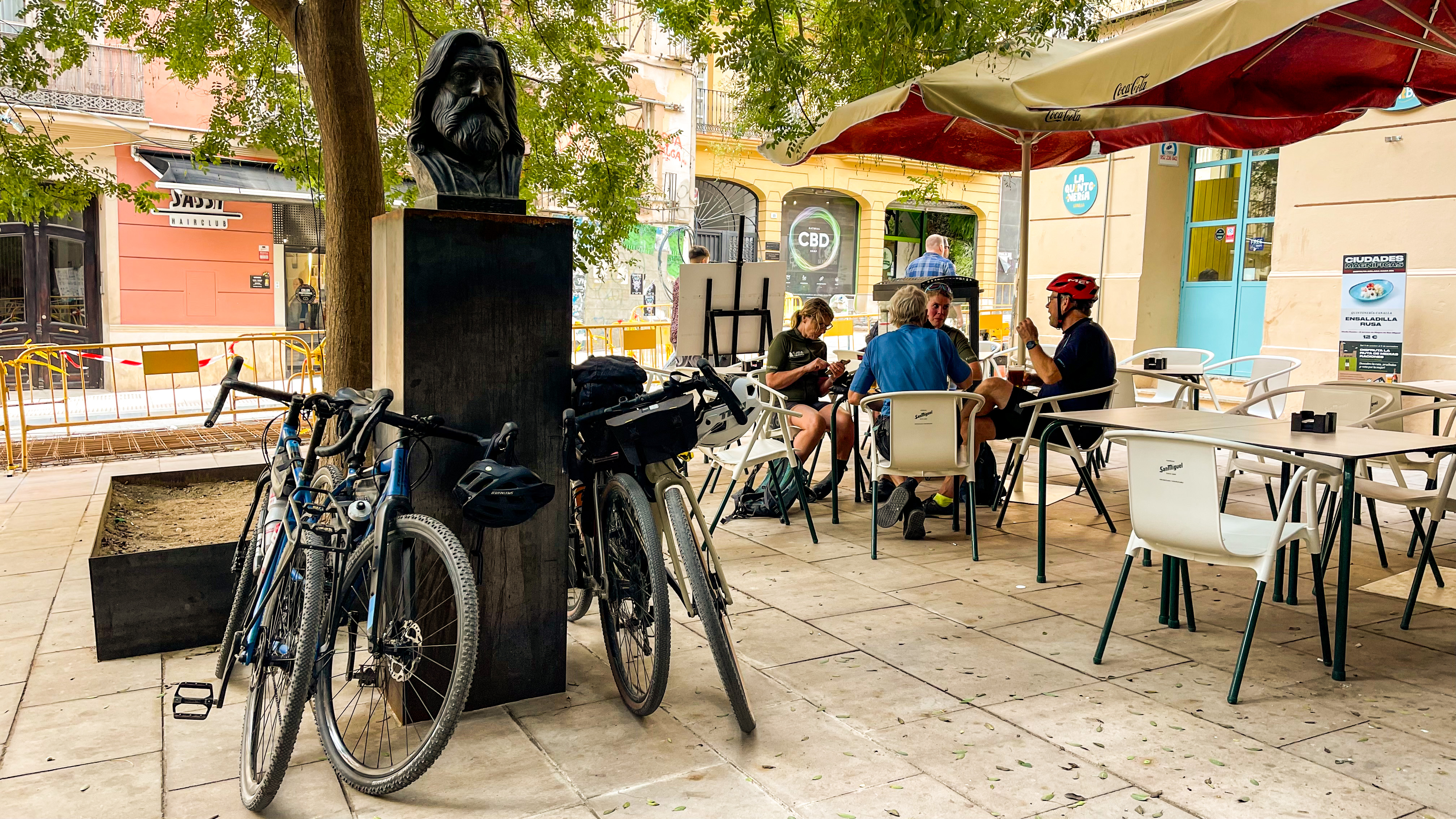 En Velfortjent Pause I Plaza De San Pedro De Alcantara. Den Døde Sanger Rockberto Fra Málagas Tabletom Vagter Over Cyklerne